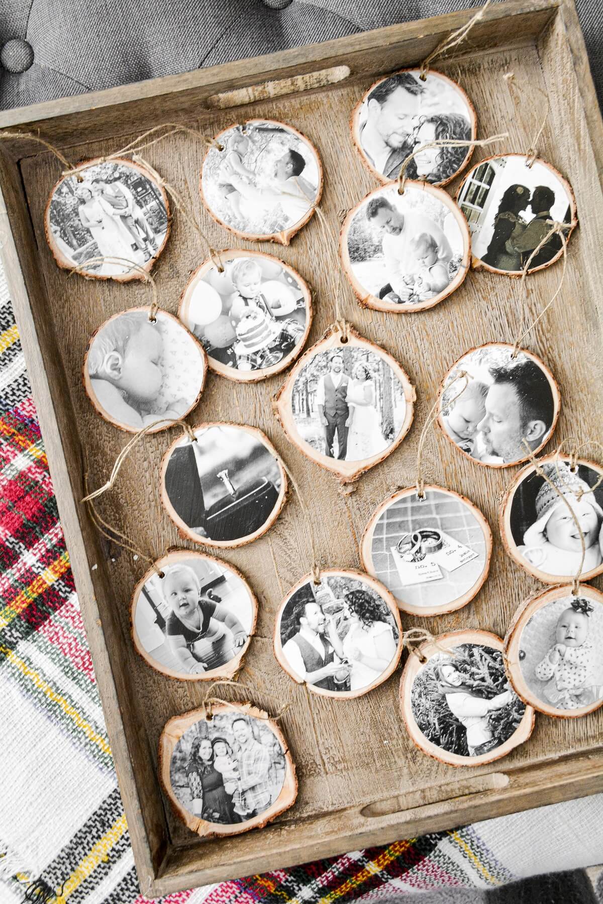 Homemade photo Christmas ornaments on a wooden tray.