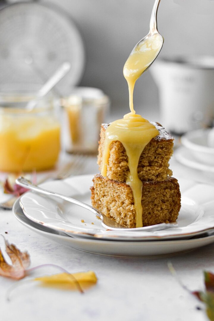Lemon curd poured over pieces of cardamom ginger cake.