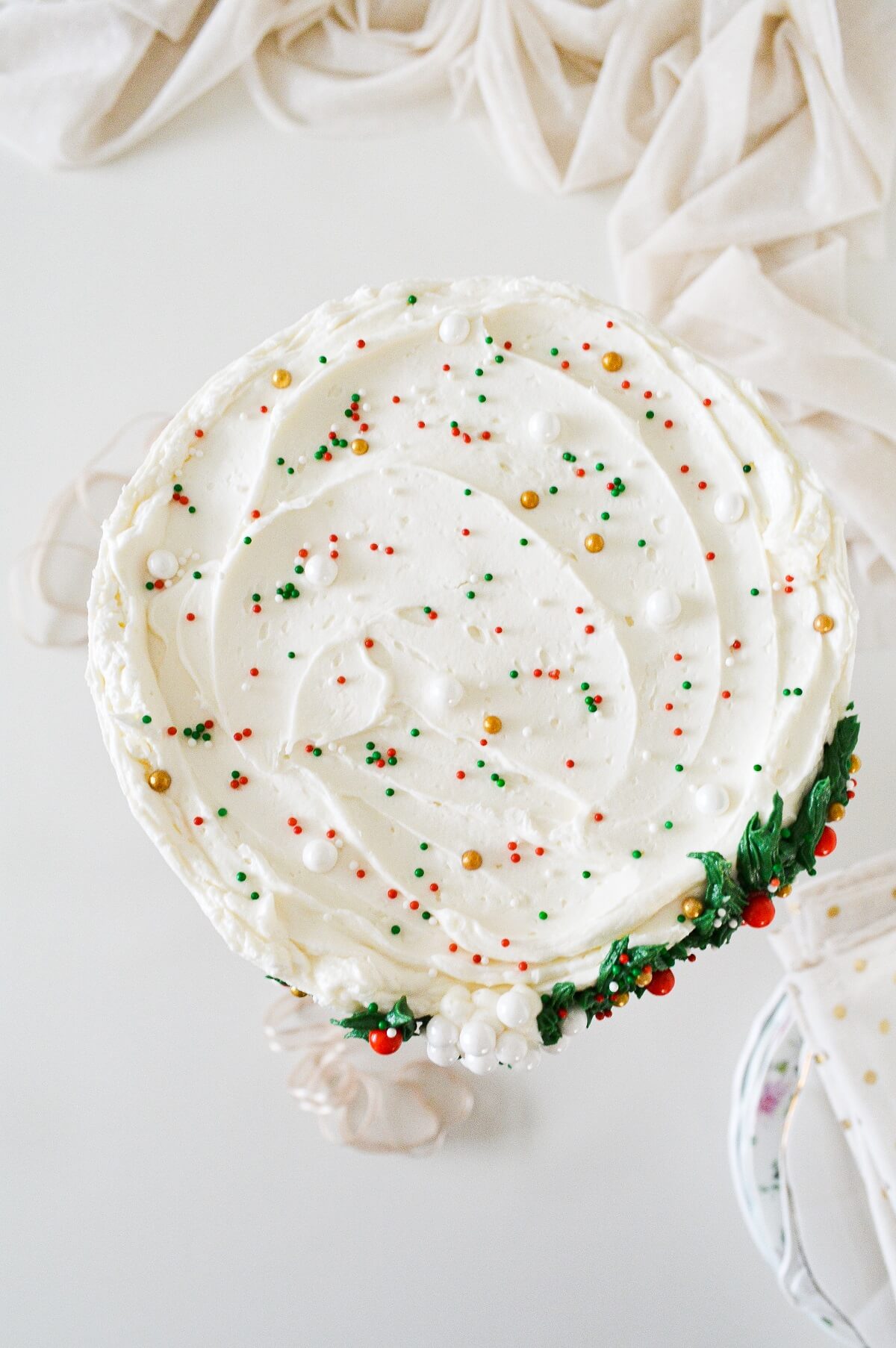 The top of a cake sprinkled with red, white, green, and gold sprinkles.