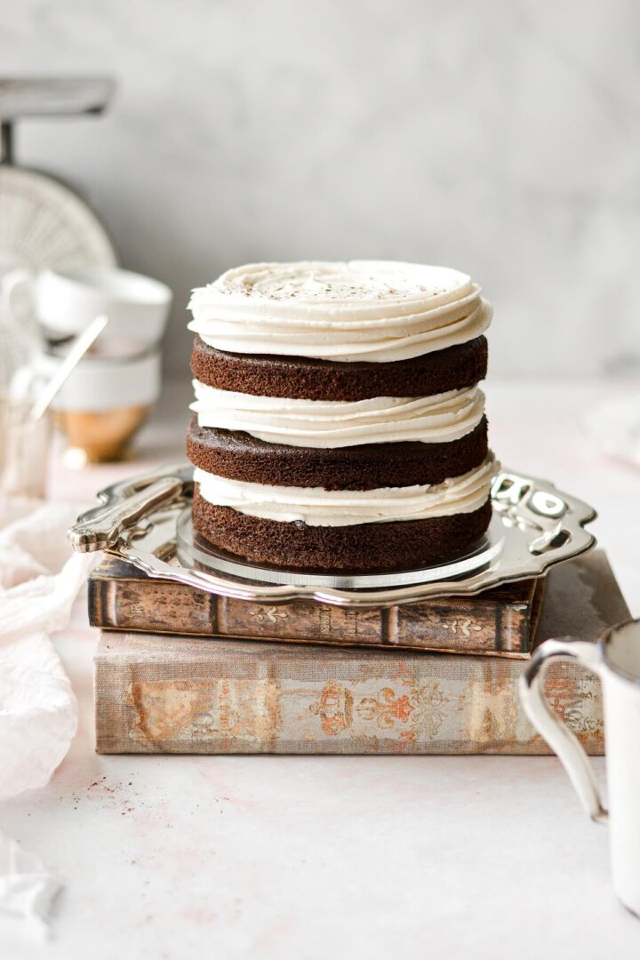 Three naked layers of spice cake, with swirls of cream cheese buttercream.