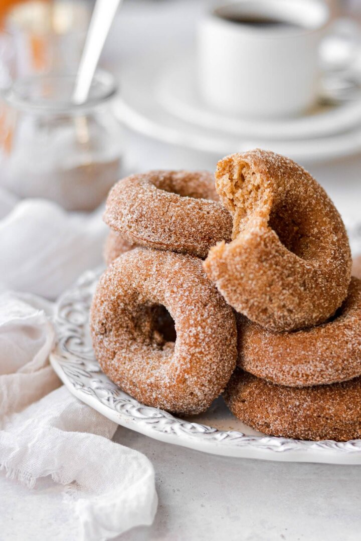 Apple cider doughnuts, one with a bite taken.