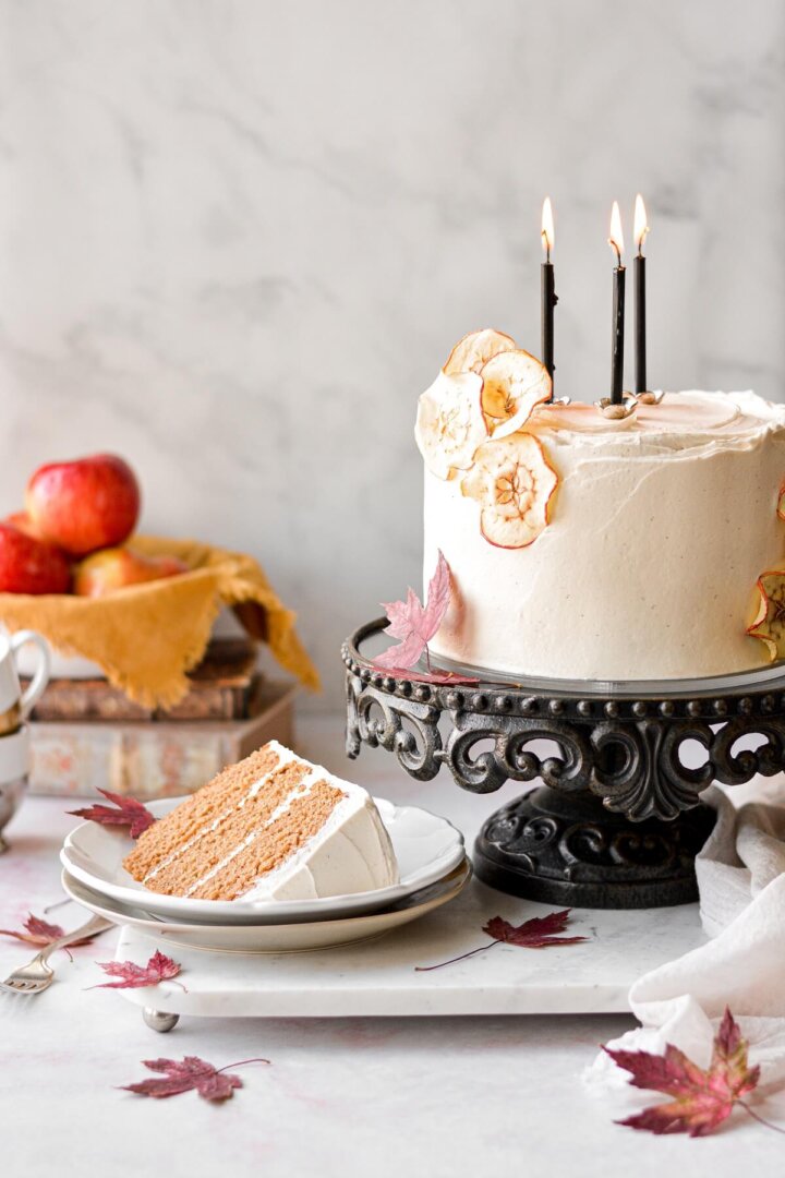 Bolo de cidra de maçã com creme de baunilha de bordo, com uma fatia cortada.