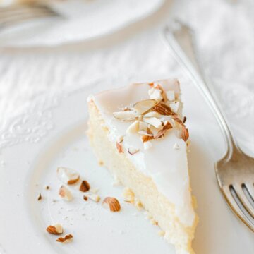 Slices of flourless almond torte on white plates.