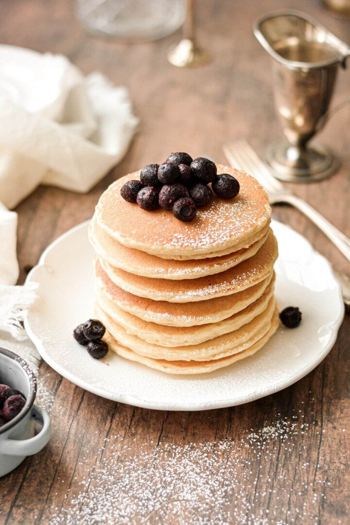A stack of the best classic pancakes, topped with blueberries.