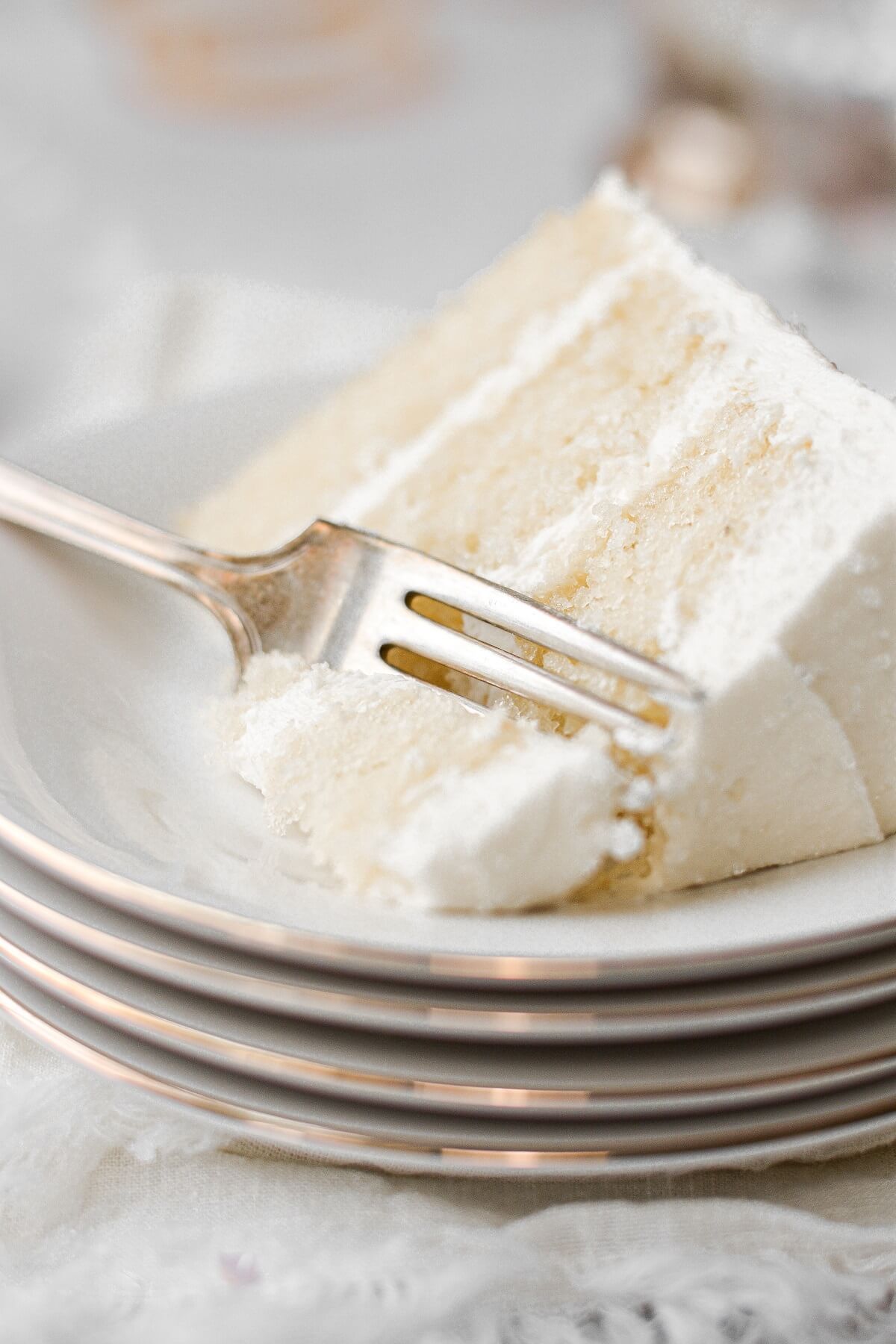 A slice of champagne cake with a bite cut.