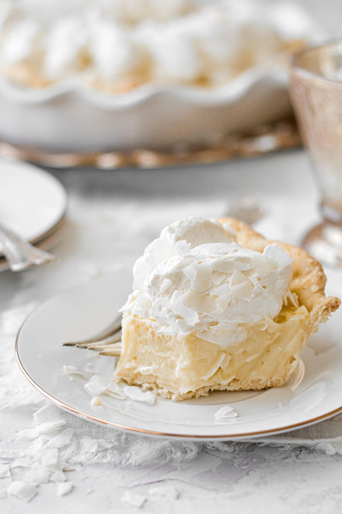 A slice of coconut cream pie with a bite taken.