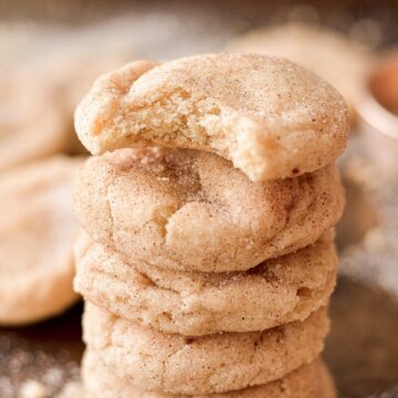 A stack of high alititude snickerdoodles, one with a bite taken out of it.