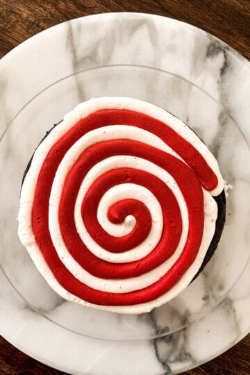 Red and white swirled buttercream for a chocolate and peppermint North Pole cake.