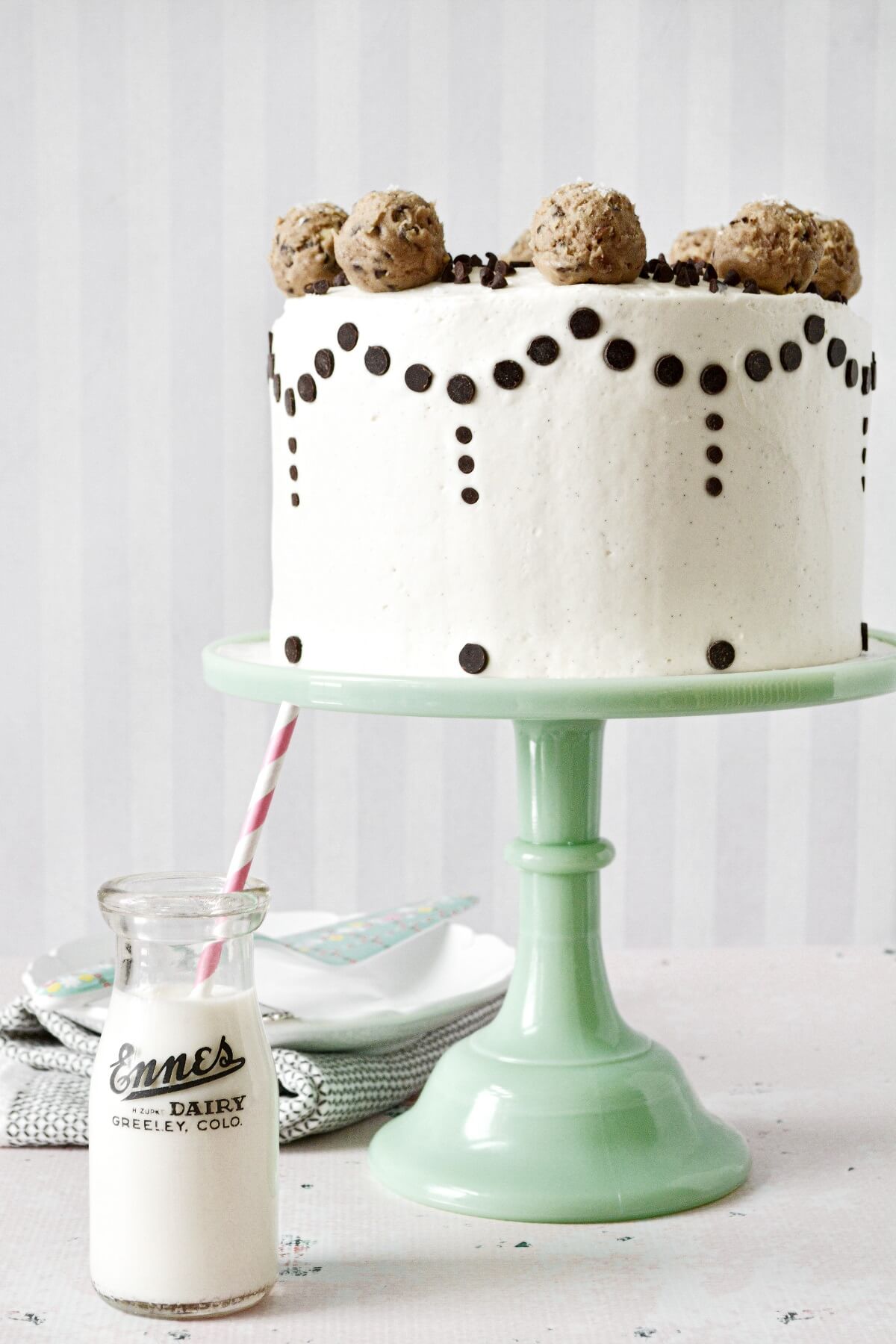 Chocolate chip cookie dough cake, decorated with chocolate chips and balls of cookie dough.