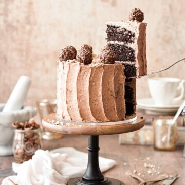 Chocolate hazelnut cake with a slice being lifted out.