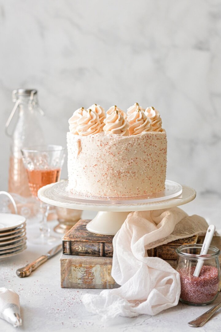 Pink champagne cake with sparkling sugar and piped swirls of buttercream.