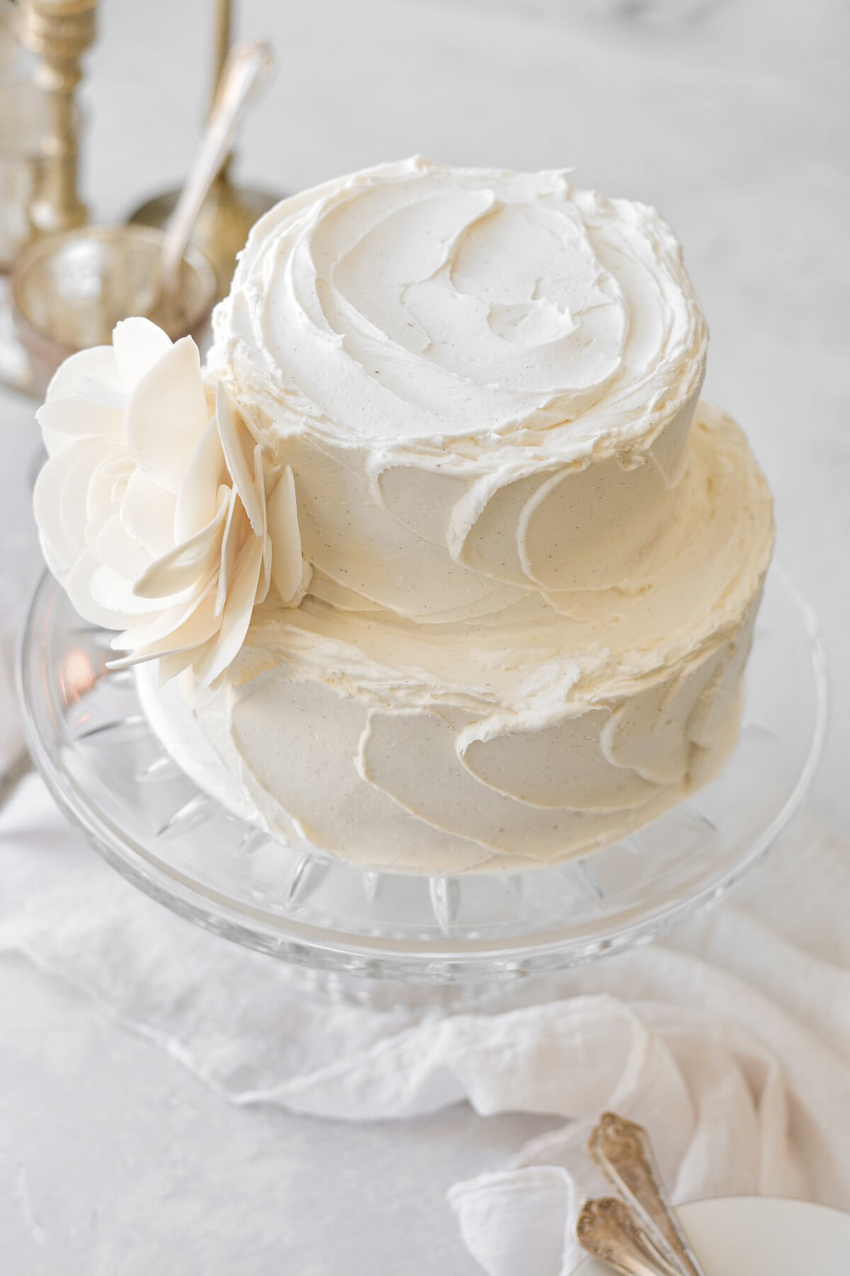 A two-tiered almond wedding cake with a white chocolate rose.