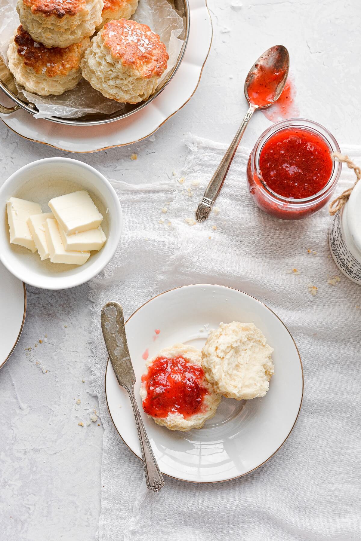 A biscuit split in half, topped with strawberry rhubarb jam.