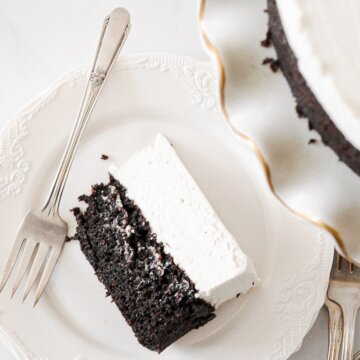 A slice of black and white cheesecake on a white plate.