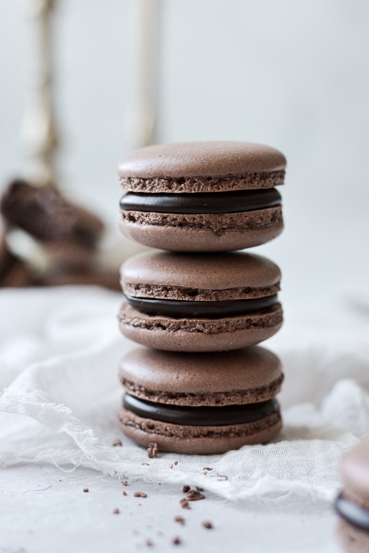 A stack of chocolate macarons, filled with dark chocolate ganache.