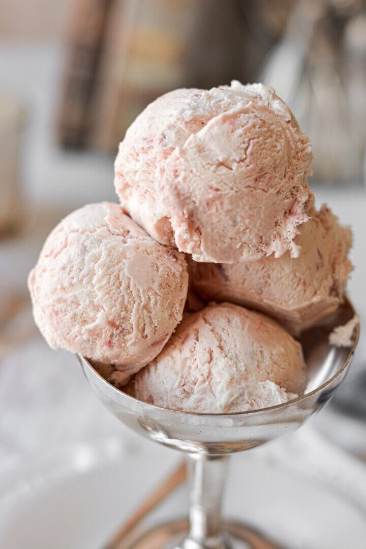 Scoops of roasted rhubarb ice cream in a silver bowl.