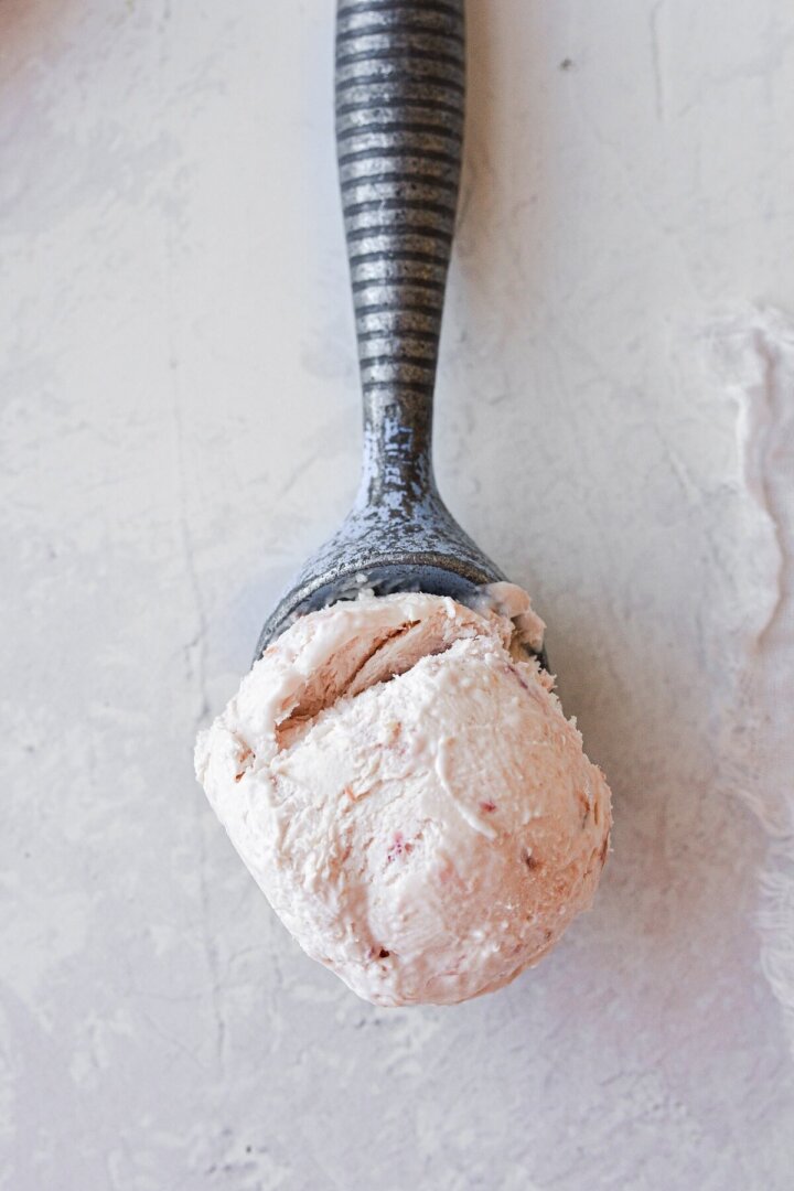 A scoop of roasted rhubarb ice cream in a vintage ice cream scoop.
