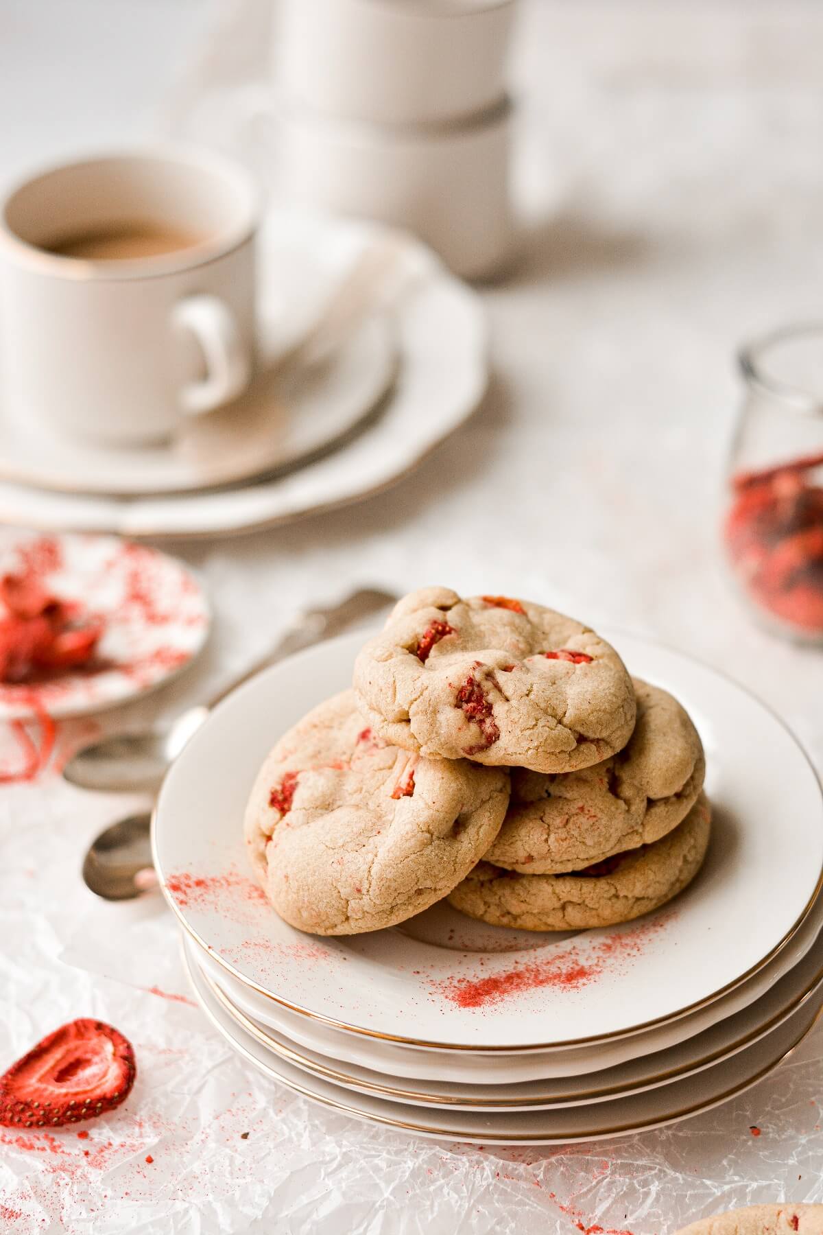 Strawberry brown butter cookies on a stack of plates.