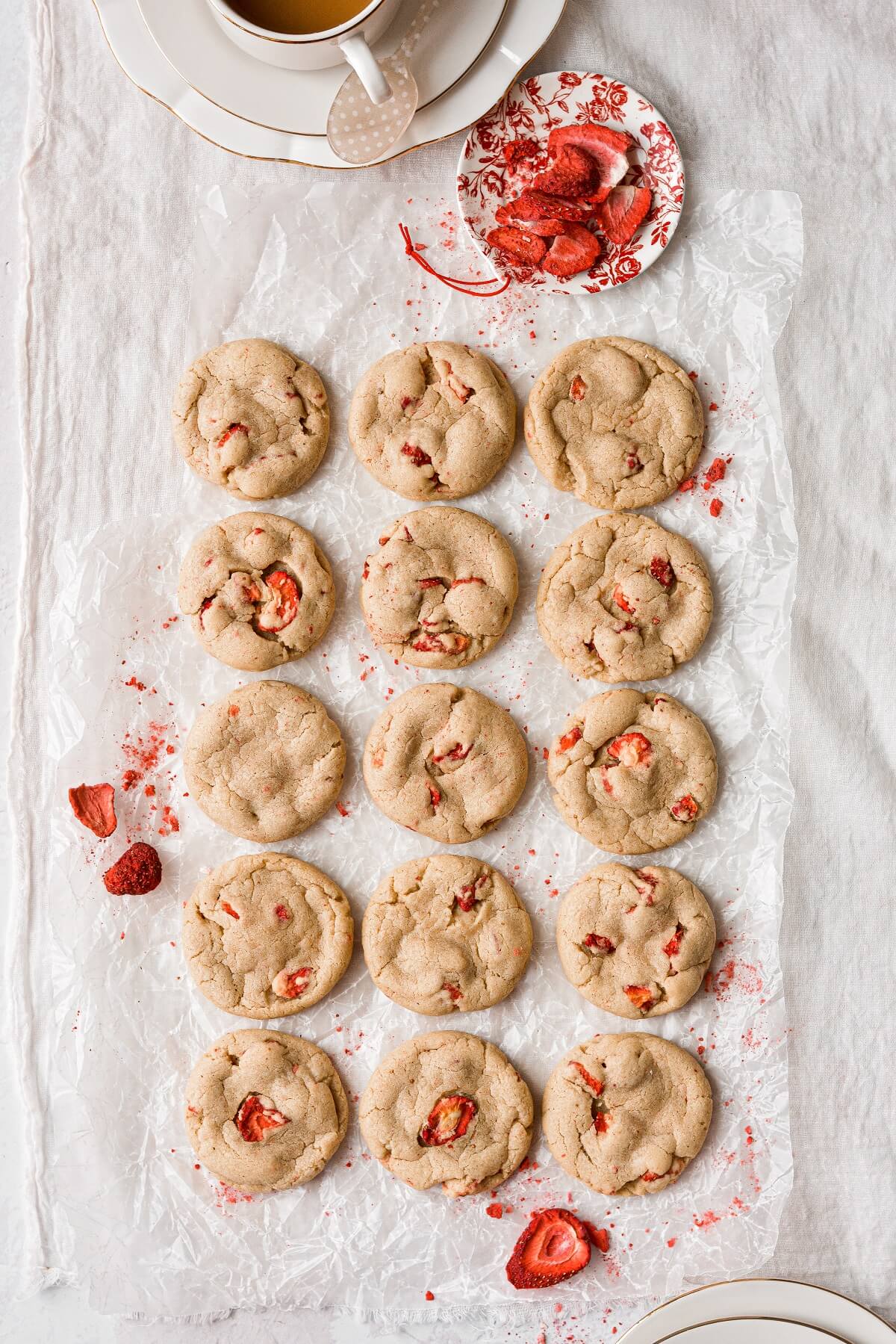 Strawberry brown butter cookies arranged on white linen.