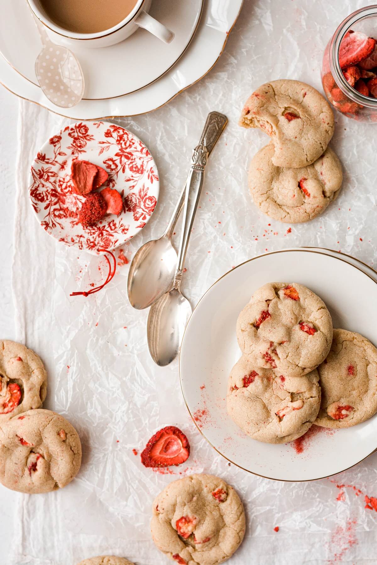 Strawberry cookies on a plate, with a cup of coffee.