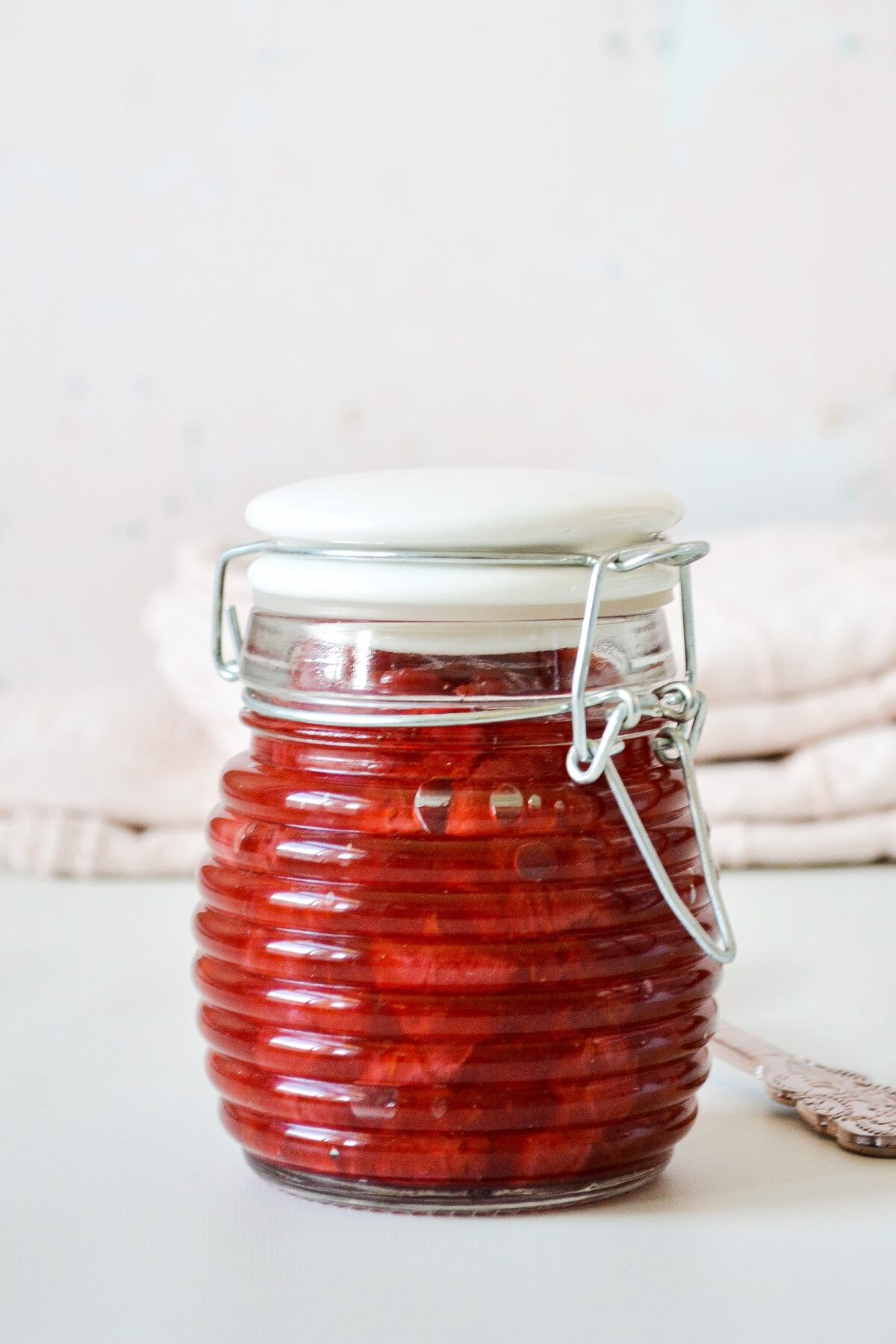 A glass jar of strawberry sauce.