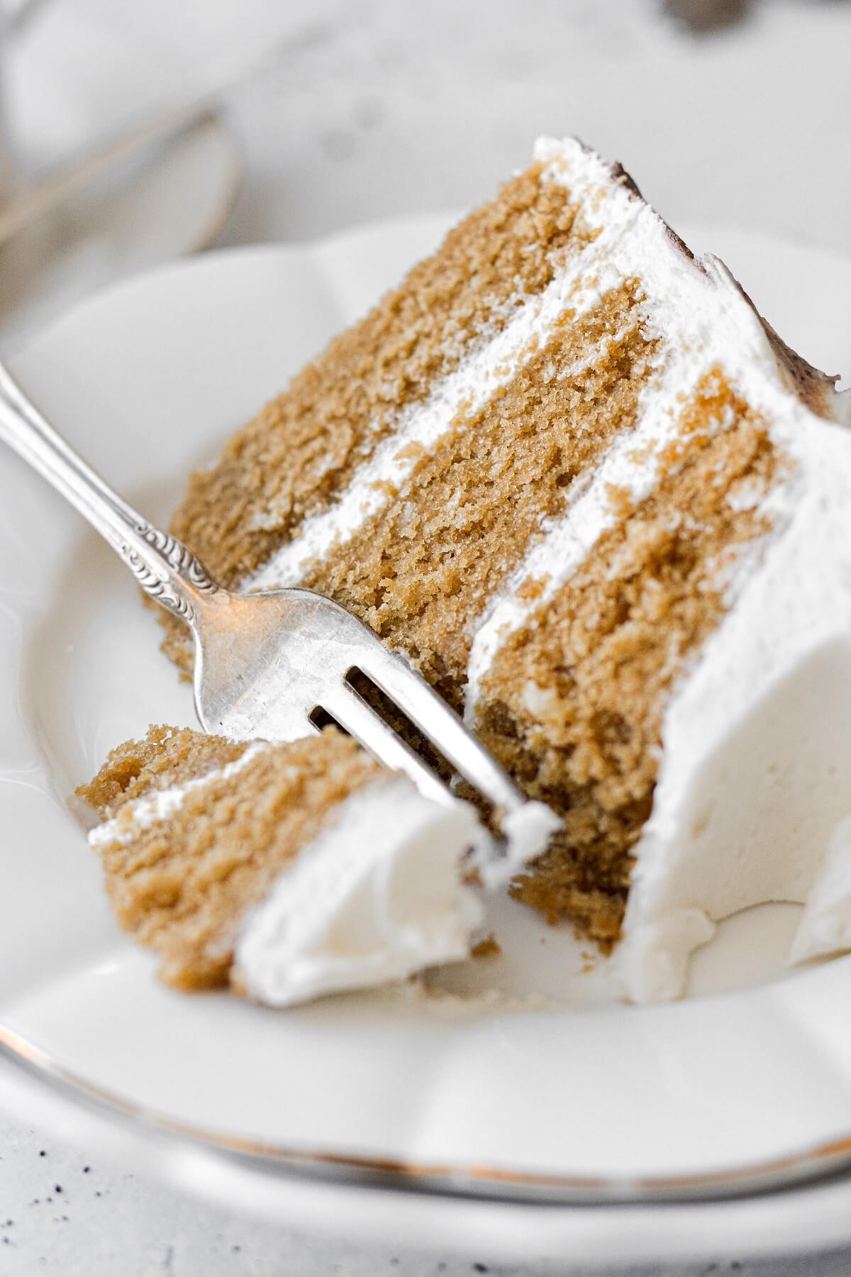 A slice of vanilla latte cake with a bite cut.