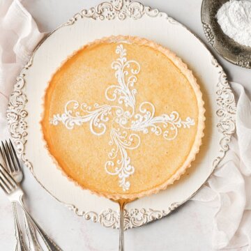 A lemon tart with a fancy powdered sugar stencil.