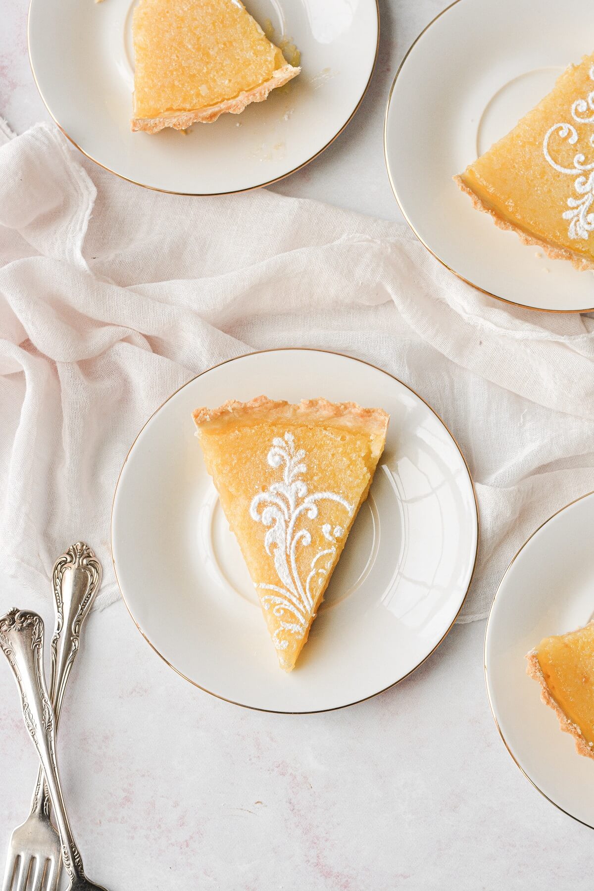 Slices of lemon tart with a powdered sugar stencil on top.