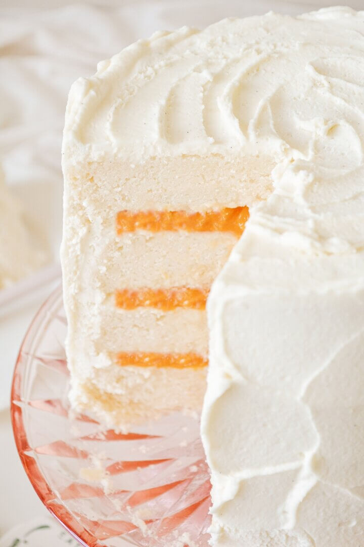 Peaches and cream cake, with one slice cut.