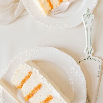 Slices of peaches and cream cake on white plates.