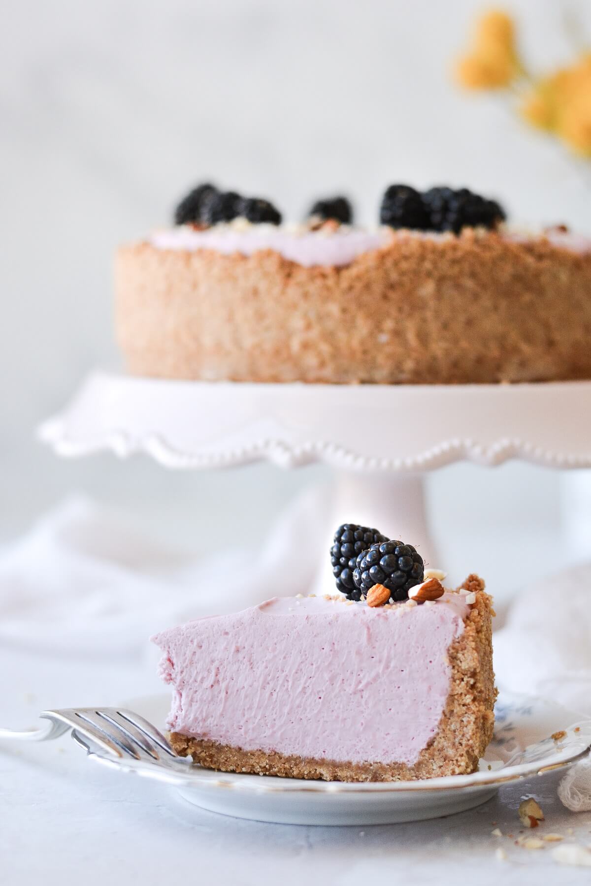 A slice of no bake blackberry cheesecake, topped with blackberries.