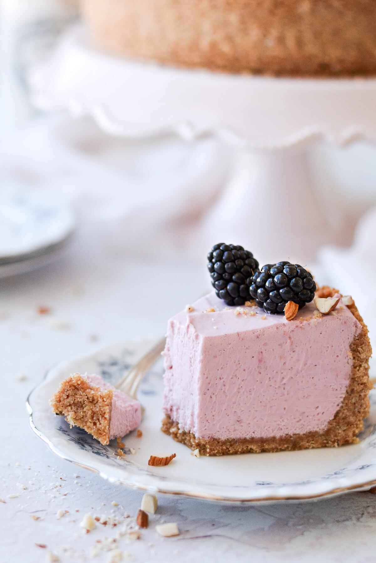 A slice of no bake blackberry cheesecake, topped with blackberries.