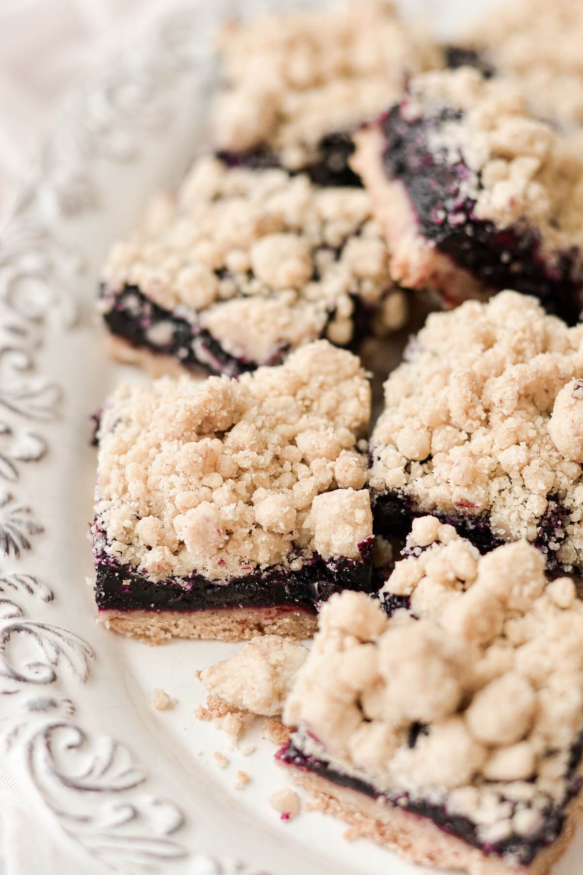 Blueberry crumb bars arranged on a plate.