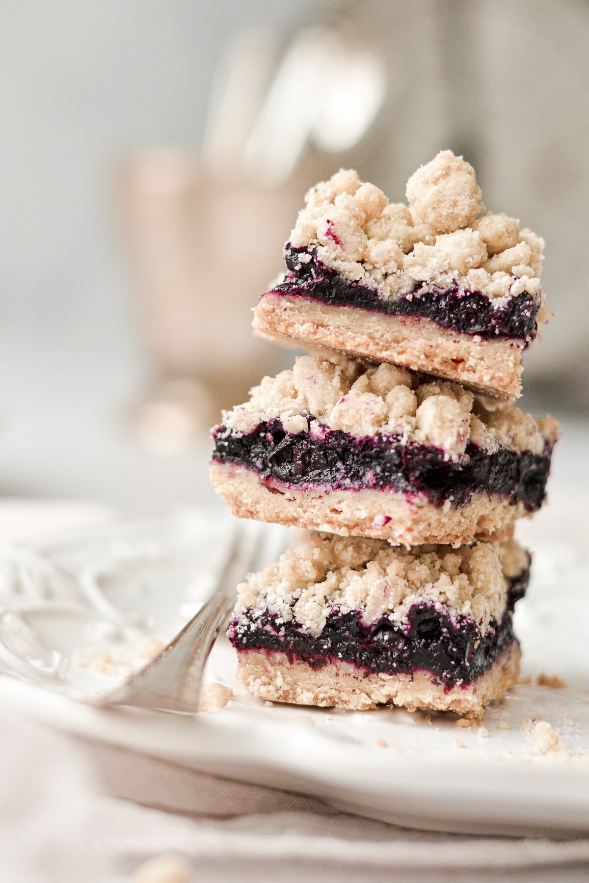 Blueberry crumb bars stacked on a plate.
