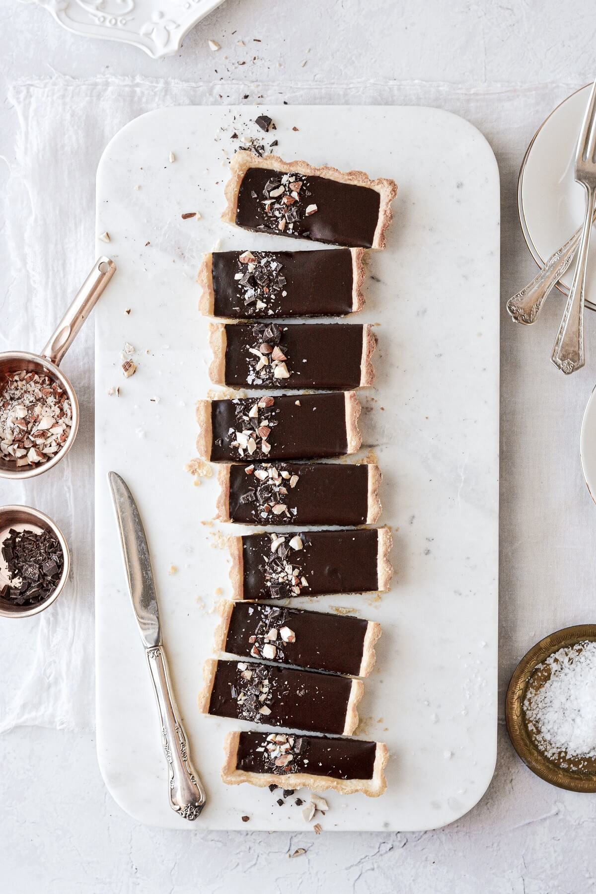 Slices of chocolate almond tart, arranged on a marble serving board.