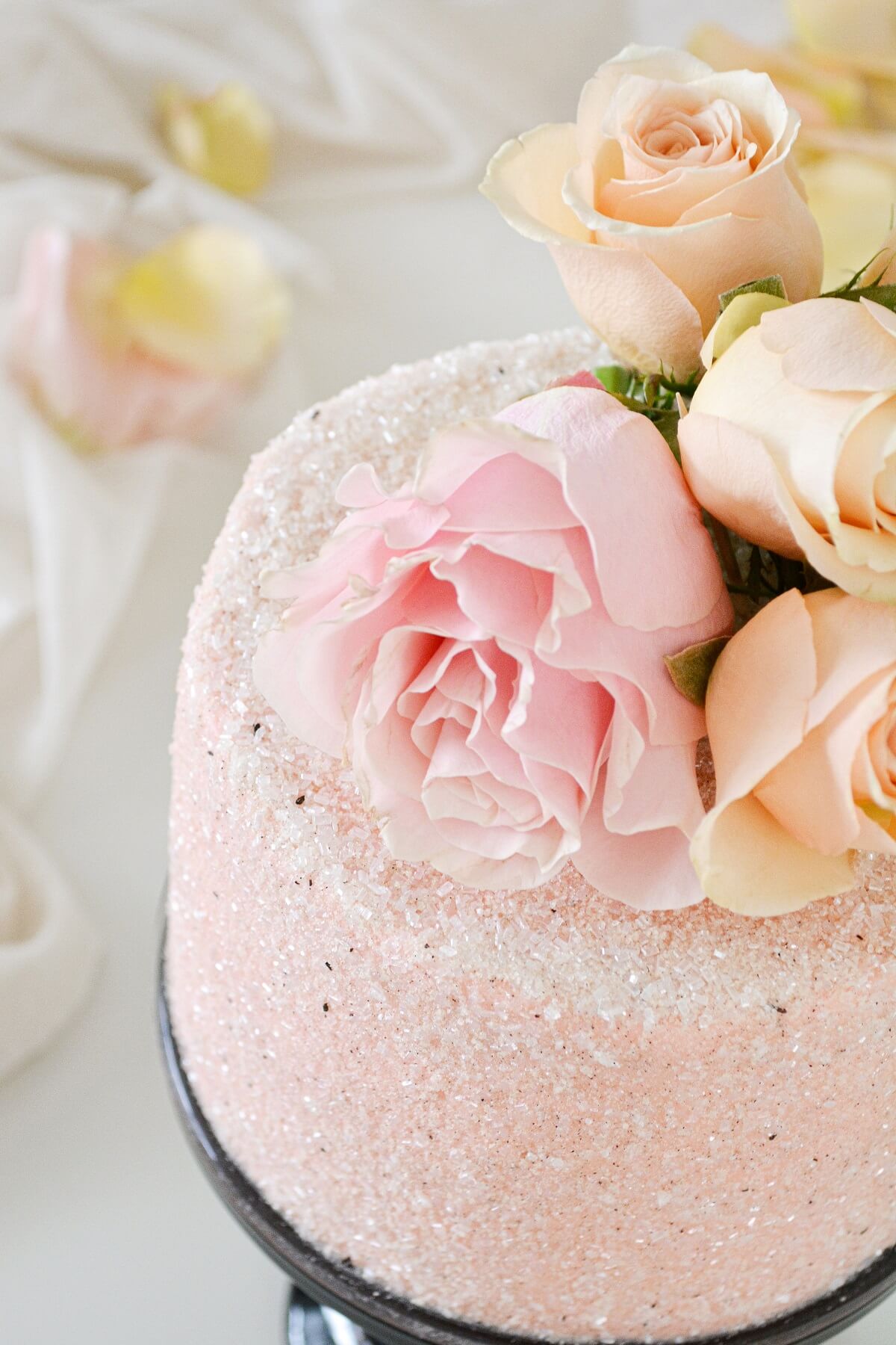 Chocolate peppermint cake, covered in pink sparkling sugar and pink and peach roses.