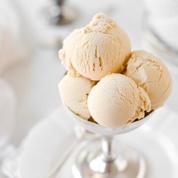 Scoops of brown sugar ice cream in a silver footed bowl.