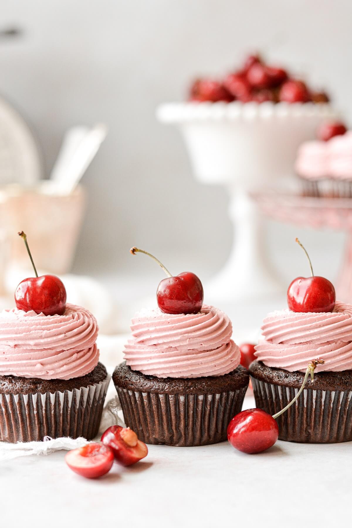 Chocolate cherry cupcakes topped with fresh cherries.