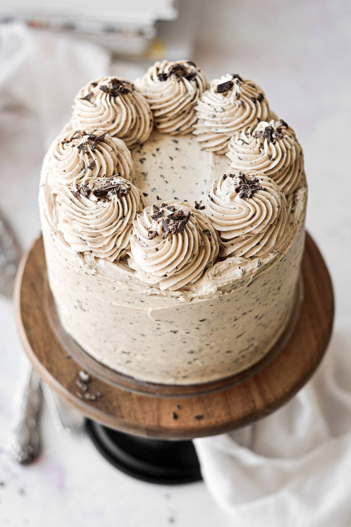Chocolate peanut butter cake topped with swirls of frosting and chopped chocolate.