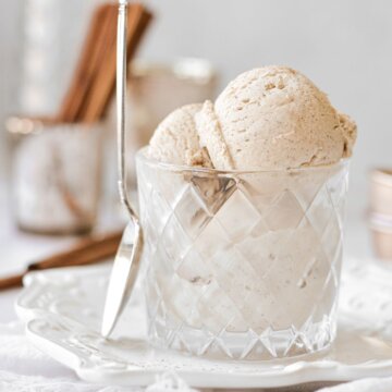 Cinnamon ice cream in a glass, with a spoon resting against the glass.
