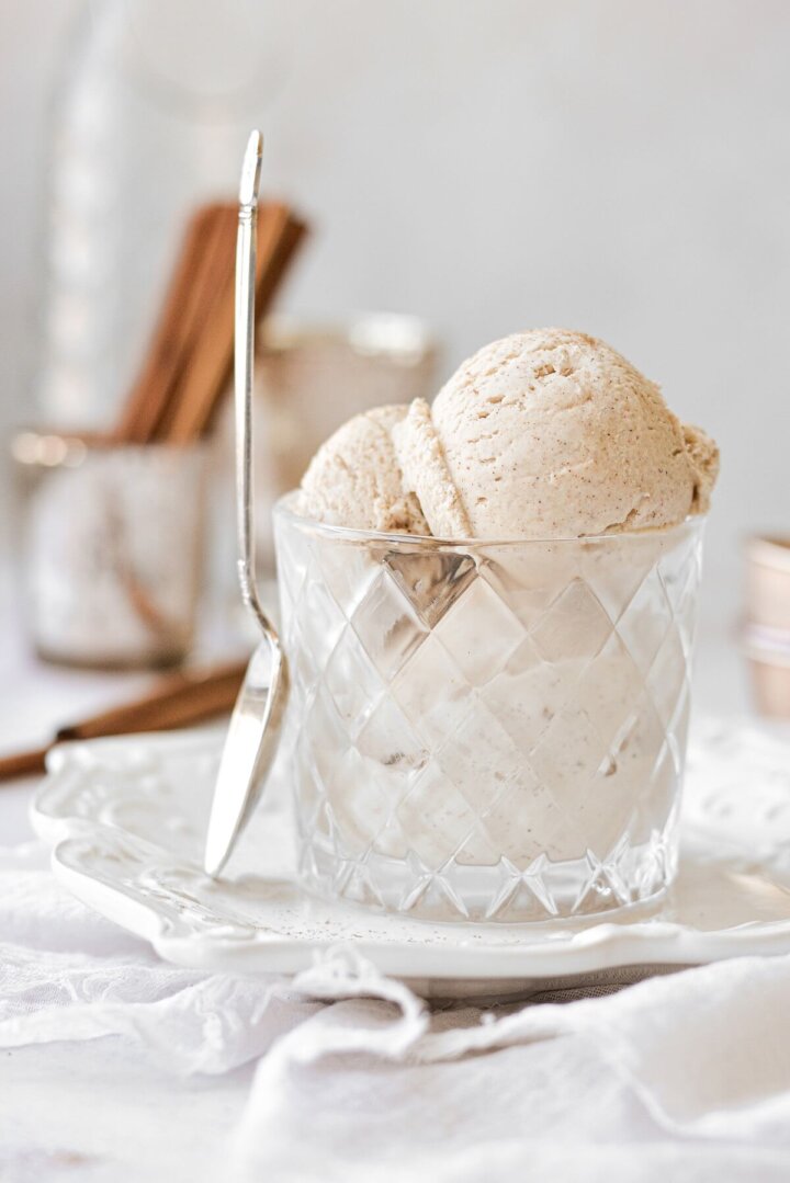 Cinnamon ice cream in a glass, with a spoon resting against the glass.
