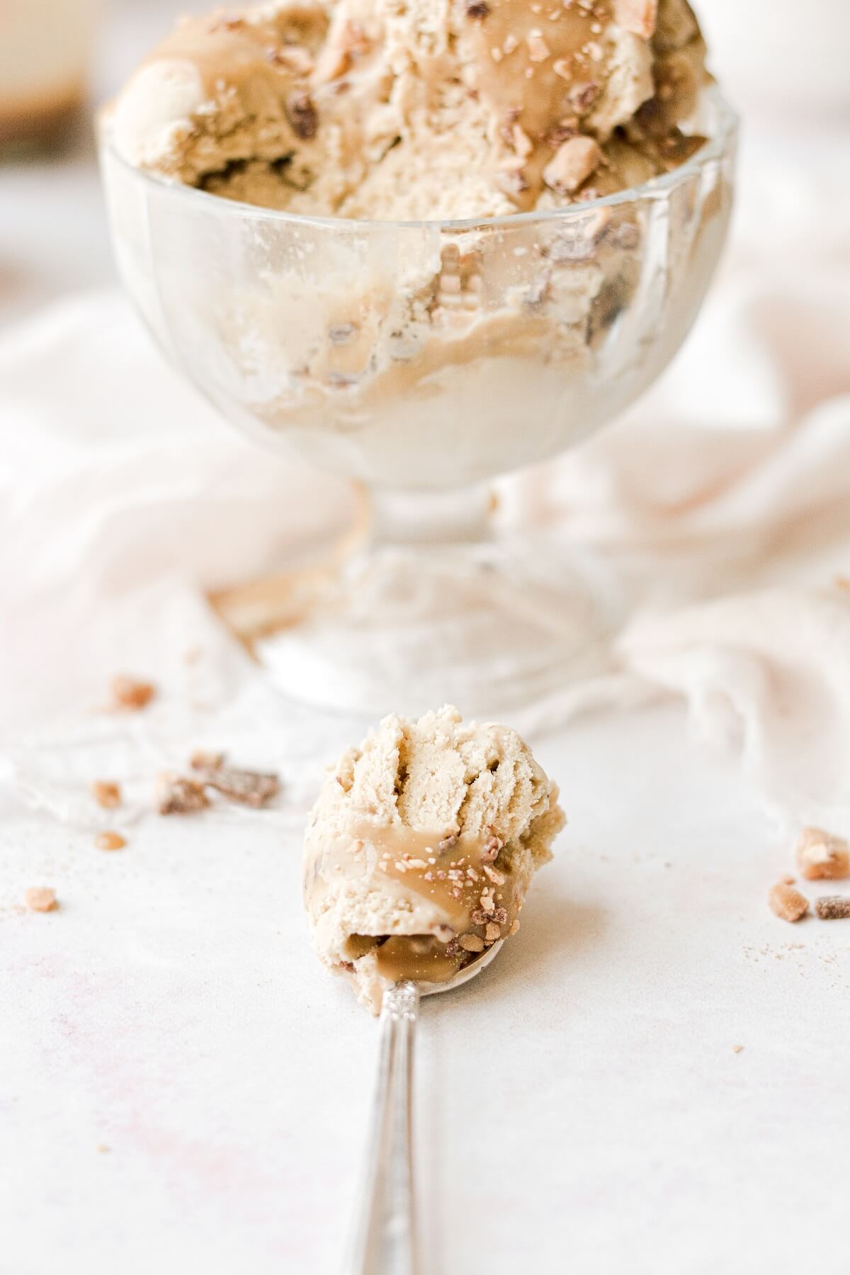 A spoonful of caramelized banana ice cream, next to a dish of ice cream.