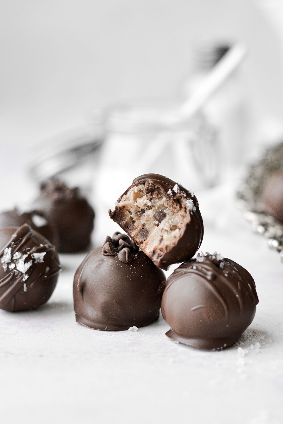 Chocolate chip cookie dough truffles, one with a bite taken.
