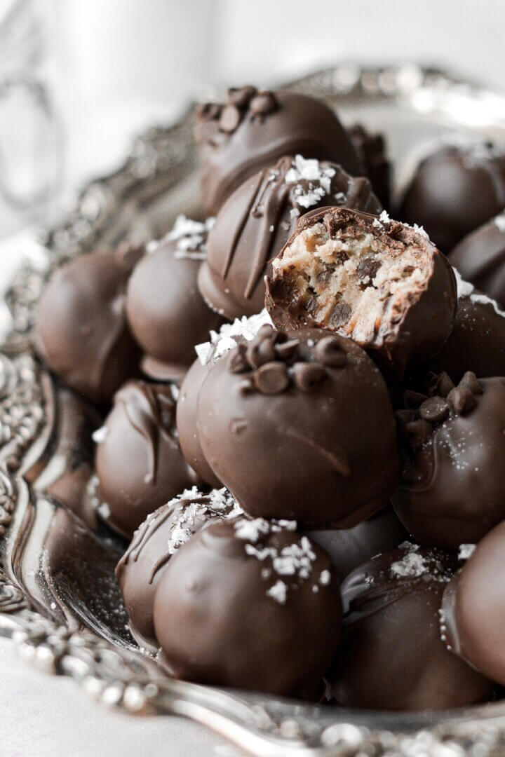 Chocolate chip cookie dough truffles, one with a bite taken.