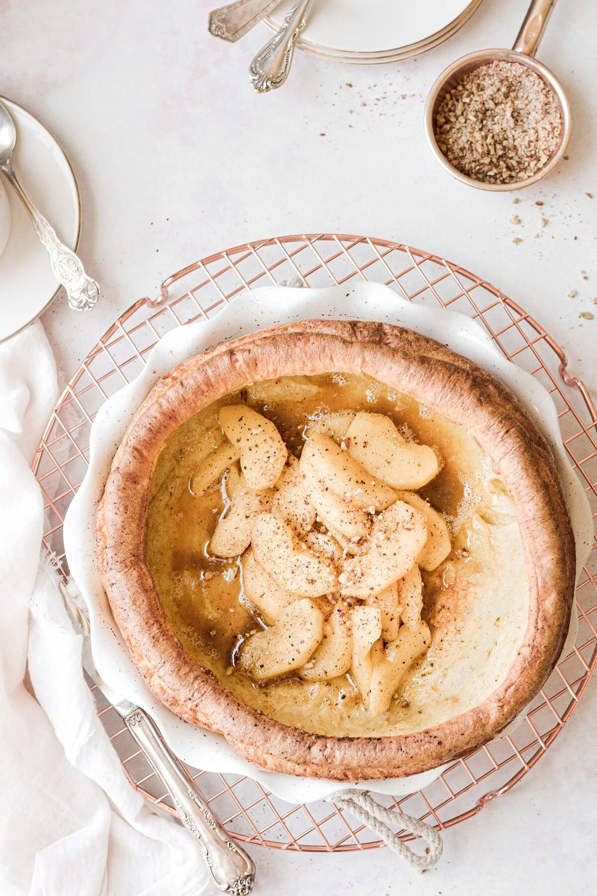 A Dutch baby pancake filled with cinnamon apples and crushed pecans.