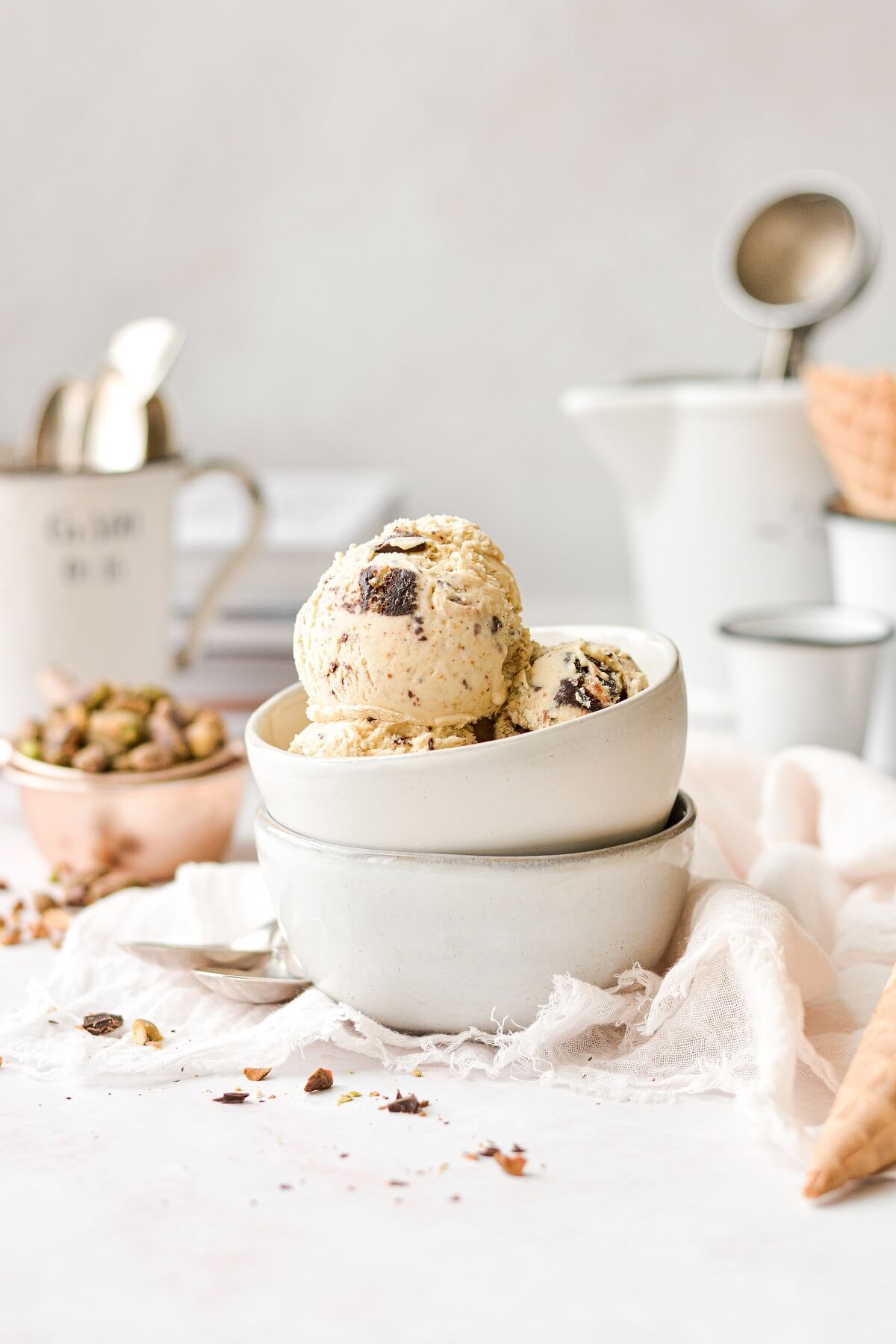 Scoops of pistachio ice cream in a stack of white bowls.