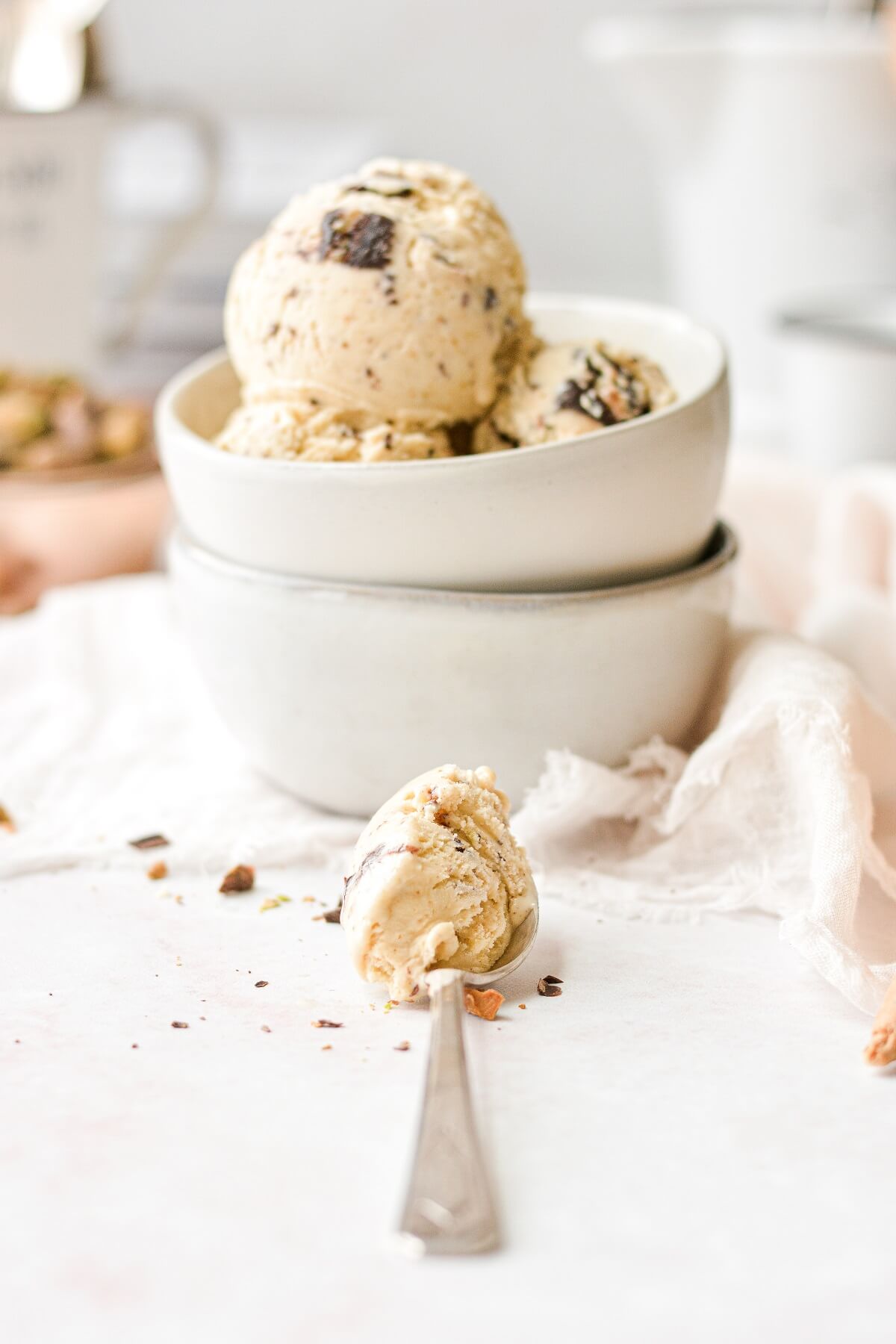 A spoonful of pistachio ice cream, next to a stack of bowls.