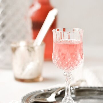 A small glass filled with pink rhubarb cordial.