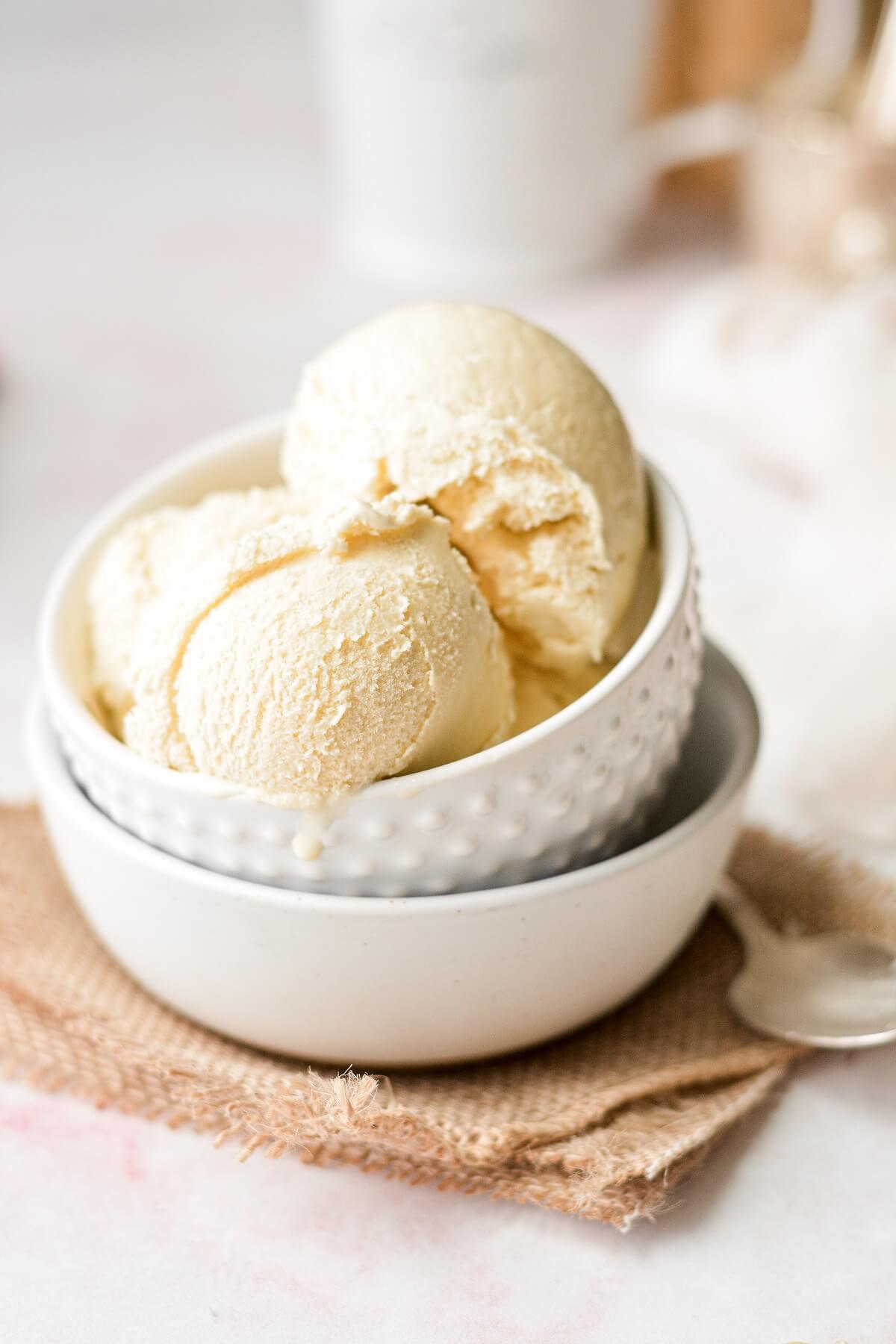 A stack of white bowls, filled with scoops of salted honey ice cream.
