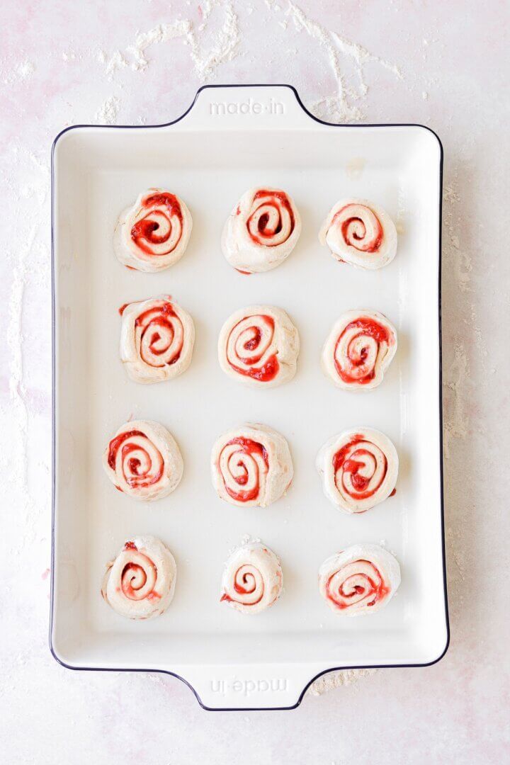 Unbaked strawberry rolls in a baking pan.